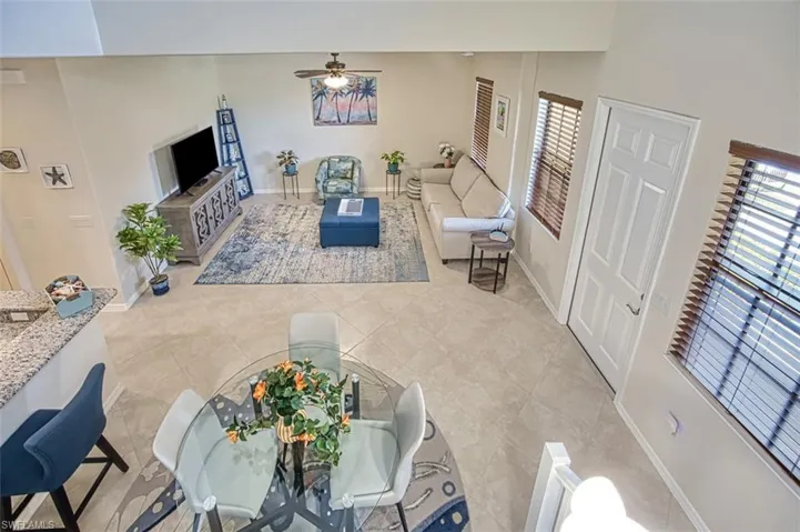 Living room featuring ceiling fan, baseboards, and tile patterned flooring