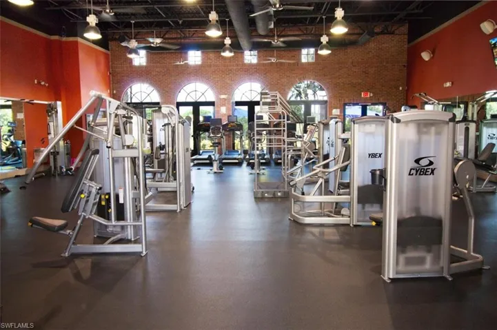 Workout area featuring brick wall and a towering ceiling