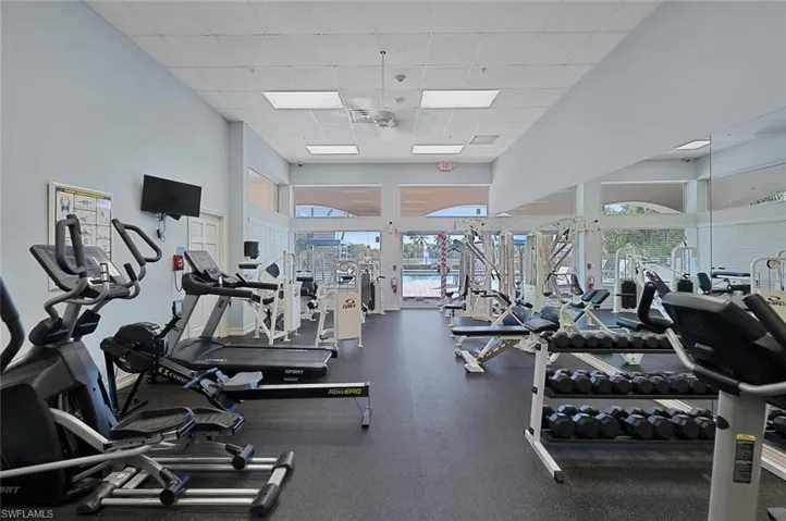 Gym featuring a paneled ceiling and a high ceiling