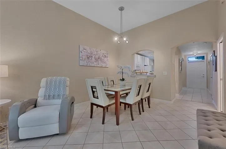 Tiled dining area featuring a chandelier and vaulted ceiling