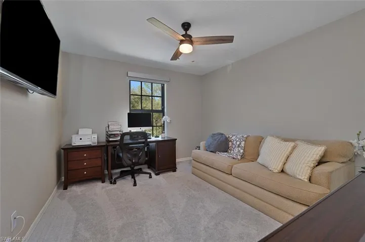 Carpeted office space featuring ceiling fan