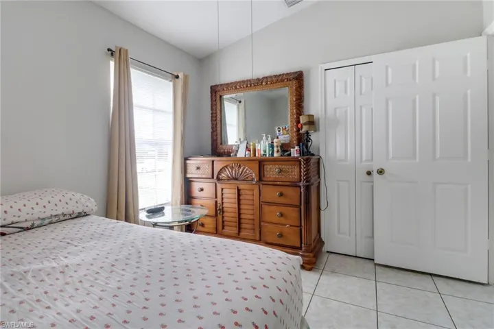 Tiled bedroom with a closet and vaulted ceiling