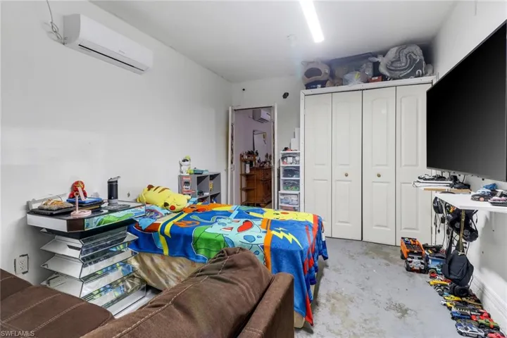 Bedroom with a closet and a wall unit AC