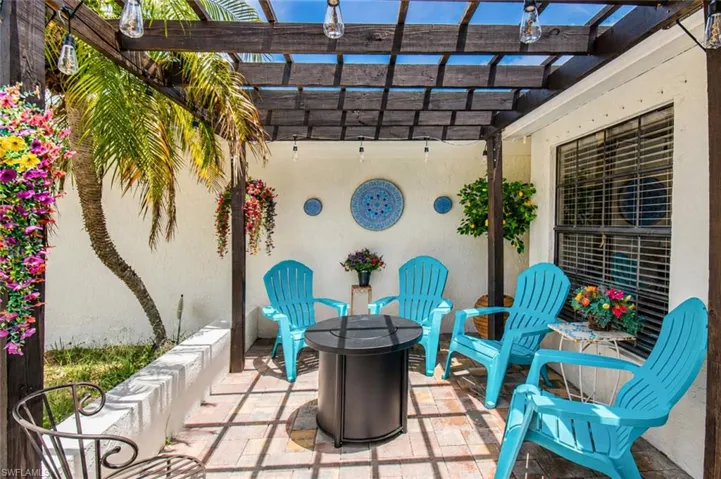 Outdoor patio with a wooden pergola, string lighting, and brick paver flooring