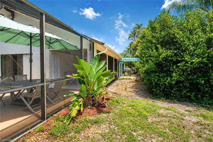 Screened patio area featuring a concrete surface and direct access to an exterior courtyard with a pergola structure