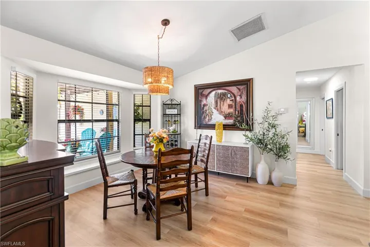 Dining area with wood-finish flooring and a tiered woven pendant light fixture
