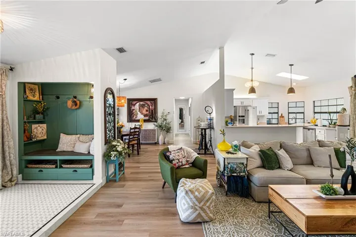Open-concept interior featuring vaulted ceilings, wood-finish flooring, and recessed lighting