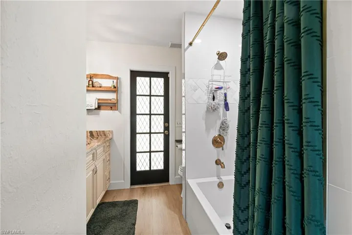 Bathroom featuring a white tub, gold-finish fixtures, and subway tile surround