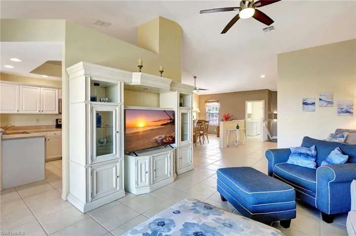 Living room with light tile patterned floors, recessed lighting, visible vents, a ceiling fan, and vaulted ceiling