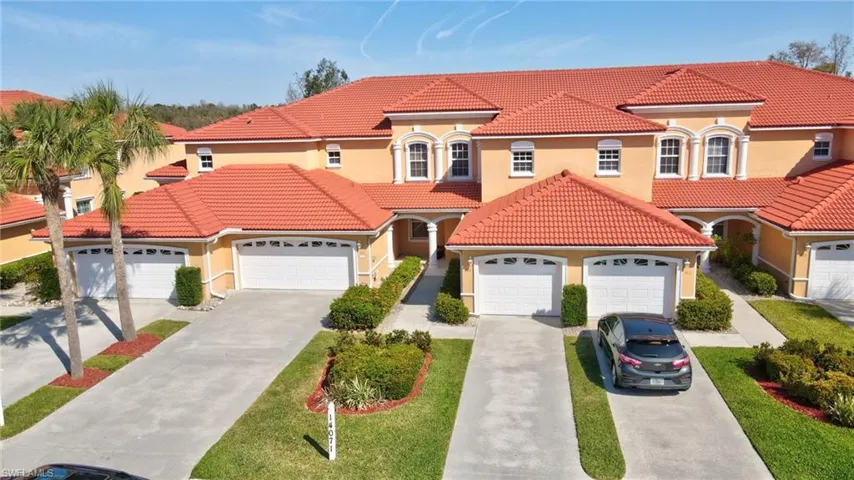 Mediterranean / spanish-style home with an attached garage, stucco siding, driveway, and a tiled roof