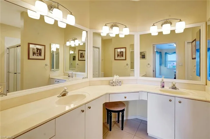 Full bath featuring double vanity, an enclosed shower, a sink, and tile patterned floors