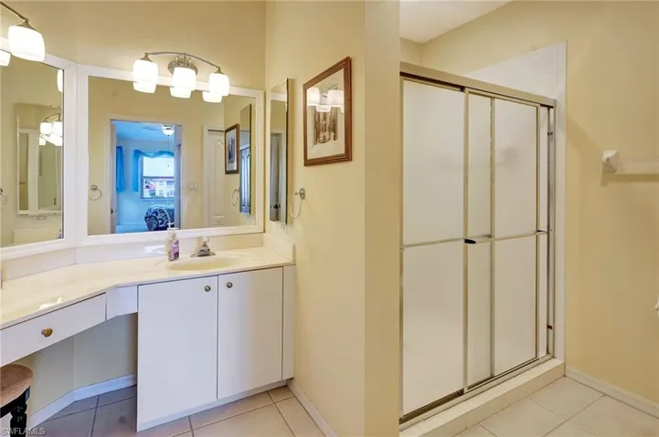 Bathroom with a stall shower, vanity, ensuite bath, and tile patterned floors