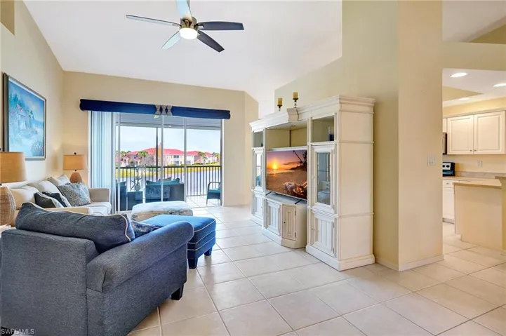Living area featuring light tile patterned floors, a ceiling fan, and baseboards
