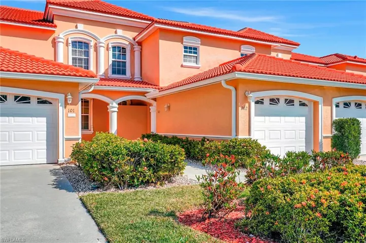 Mediterranean / spanish-style home featuring an attached garage, a tile roof, and stucco siding