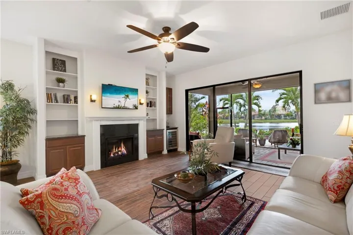 Living room featuring dark wood-type flooring and ceiling fan with notable chandelier