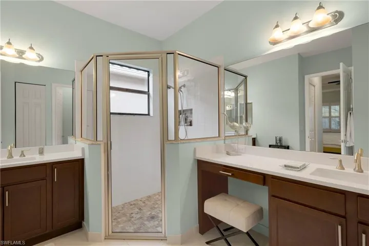 Bathroom with ceiling fan, an enclosed shower, and vanity
