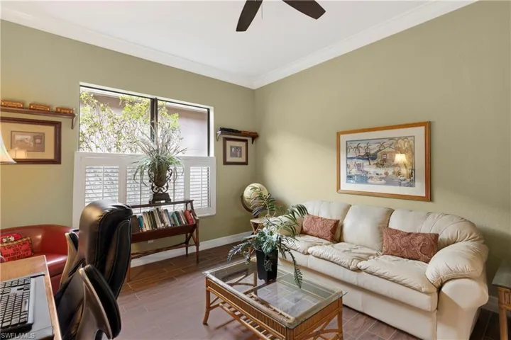 Den featuring ceiling fan, dark hardwood / wood-style flooring, and crown molding