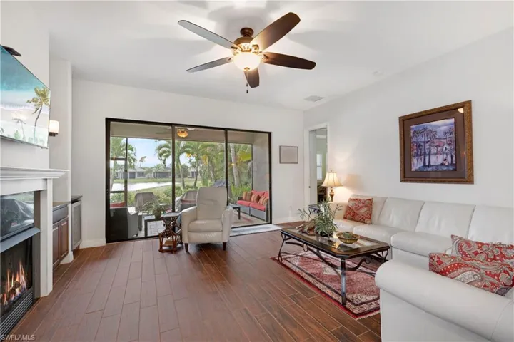 Living room featuring ceiling fan, 50 bottle wine cooler, built in cabinets, and hardwood / wood-style floors