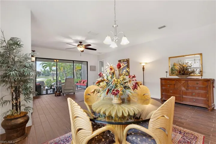 Living room featuring a premium gas fireplace, dark hardwood / wood-style flooring, and ceiling fan