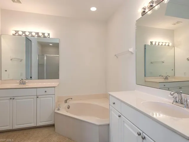 Master bath featuring separate vanities,  shower and tub.