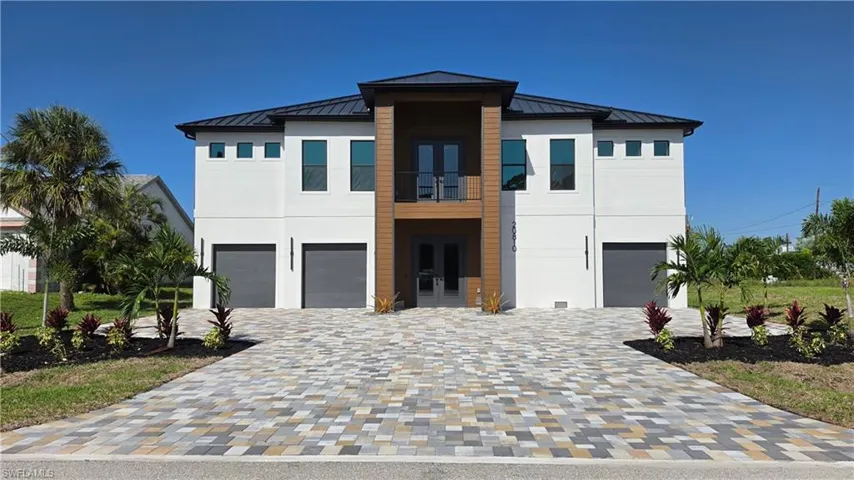 Modern architectural residence featuring a dark metal roof and white exterior