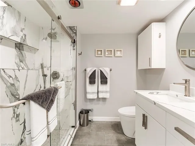 Full bathroom with vanity and a marble finish shower