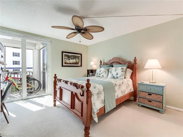 Bedroom featuring access to outside, carpet, a ceiling fan, and a textured ceiling