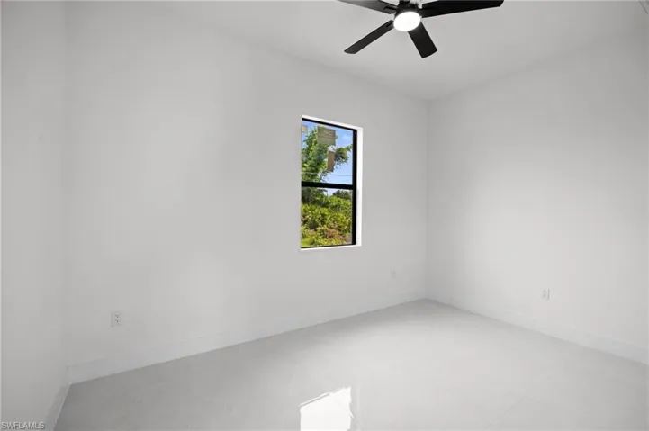 Bright room featuring a single window, white walls, and light-toned tile flooring
