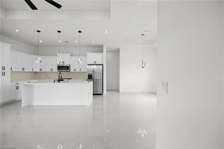 Modern kitchen featuring white cabinetry, a large center island, and stainless steel appliances