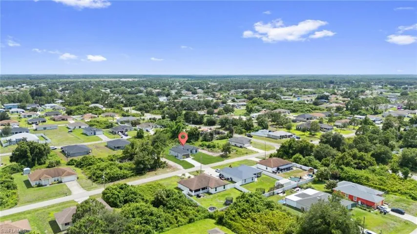 Aerial perspective showcasing a residential neighborhood with single-story homes, mature trees, and paved streets