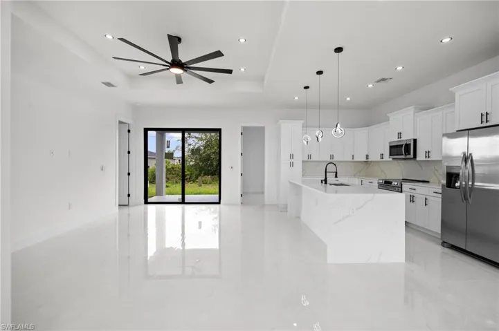 Open-concept living space with polished tile flooring, a modern ceiling fan, and recessed lighting