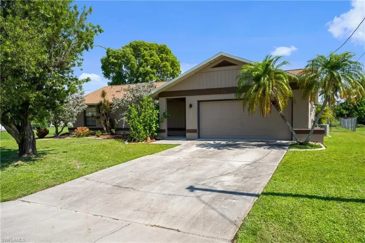 Single story home with concrete driveway, an attached garage, a front yard, and stucco siding