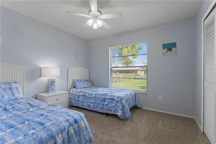 Carpeted bedroom with a closet and ceiling fan