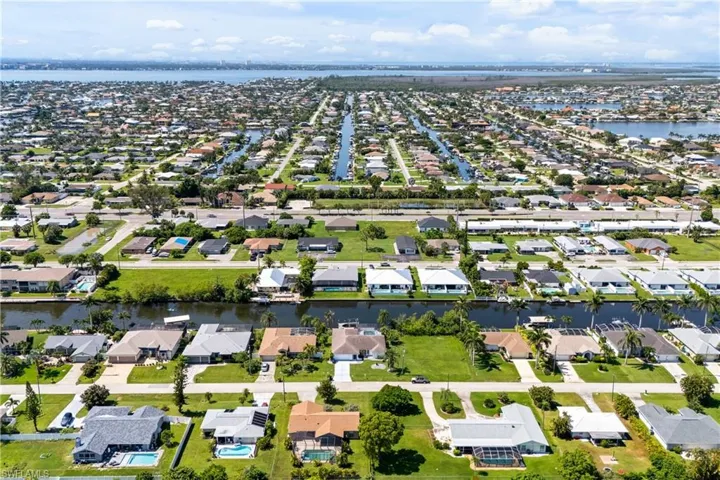 Aerial view of property's location featuring a large body of water and nearby suburban area