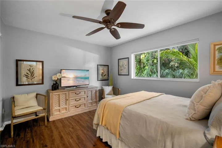 Bedroom with ceiling fan and dark wood-type flooring