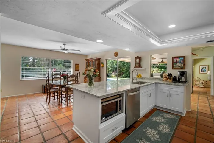 Kitchen featuring kitchen peninsula, white cabinetry, sink, and stainless steel appliances