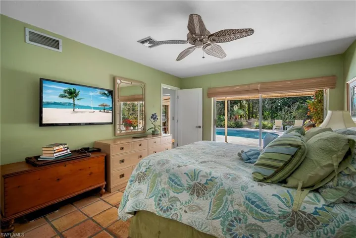 Bedroom with access to exterior, ceiling fan, and light tile patterned floors