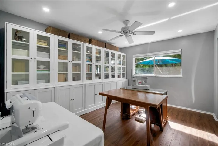Office area with ceiling fan and dark wood-type flooring