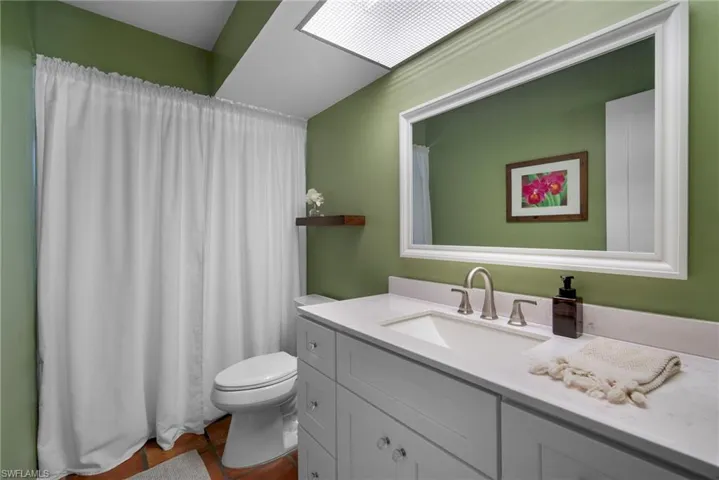 Bathroom with a skylight, vanity, and toilet