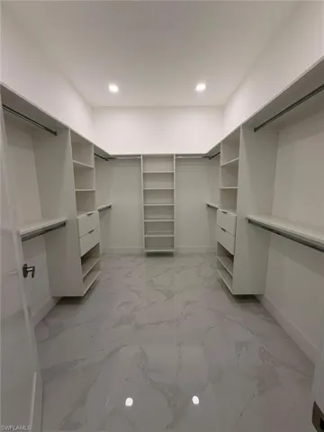 Walk in closet with light marble finish flooring
