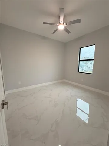 Unfurnished room with light marble finish flooring and baseboards