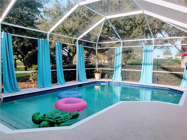 View of pool featuring lanai enclosure and a patio area