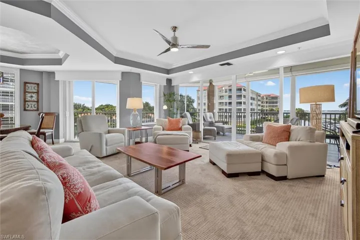 Expansive living space with recessed lighting, tray ceiling, and a ceiling fan