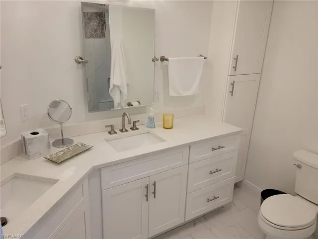 Master bath with dual sinks, tile floors, linen cabinet, light, right and neutral.