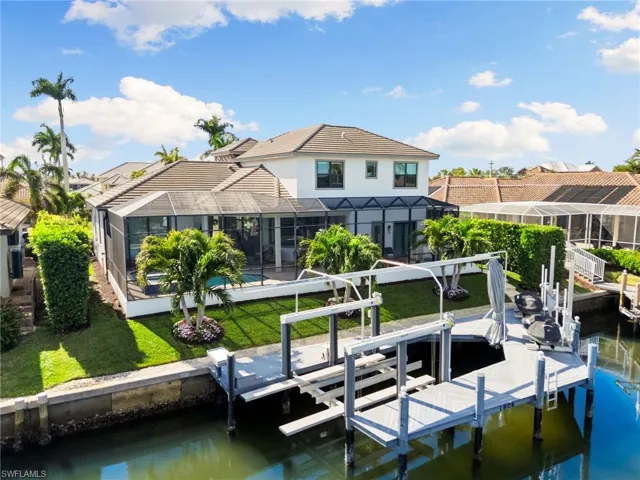 Dock area with a lanai, a yard, and a water view