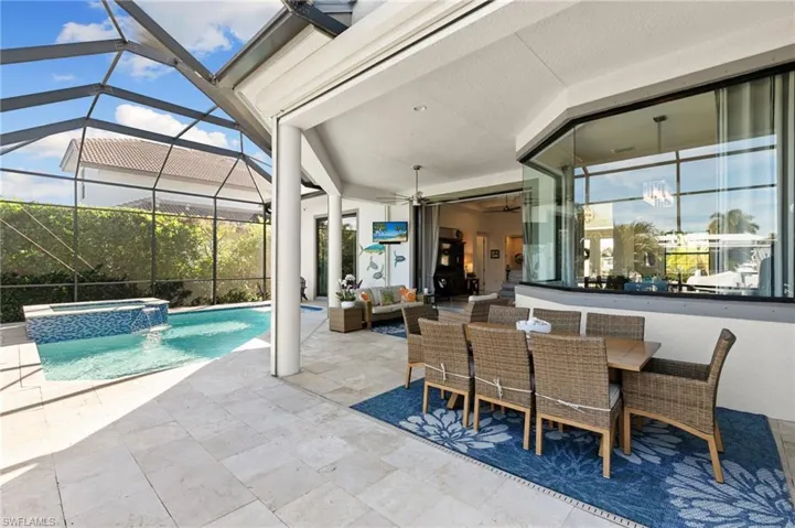 View of swimming pool featuring outdoor lounge area, a patio, a pool with connected hot tub, a lanai, and a sunroom