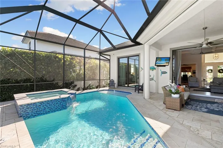 View of swimming pool with a pool with connected hot tub, a sunroom, a patio area, and a lanai