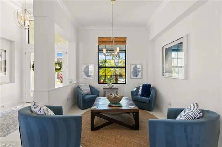 Living area featuring a chandelier and crown molding