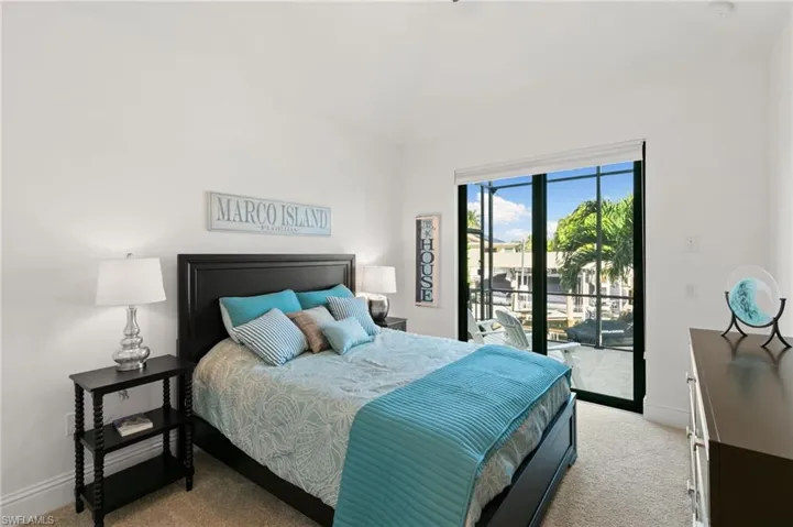 Carpeted bedroom with baseboards and access to exterior