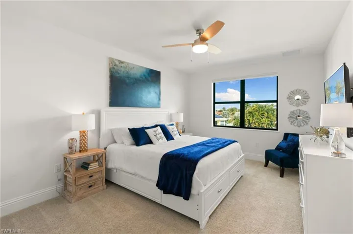 Bedroom with ceiling fan and light carpet